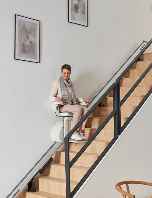 photographie d'une femme utilisant un fauteuil monte escalier droit